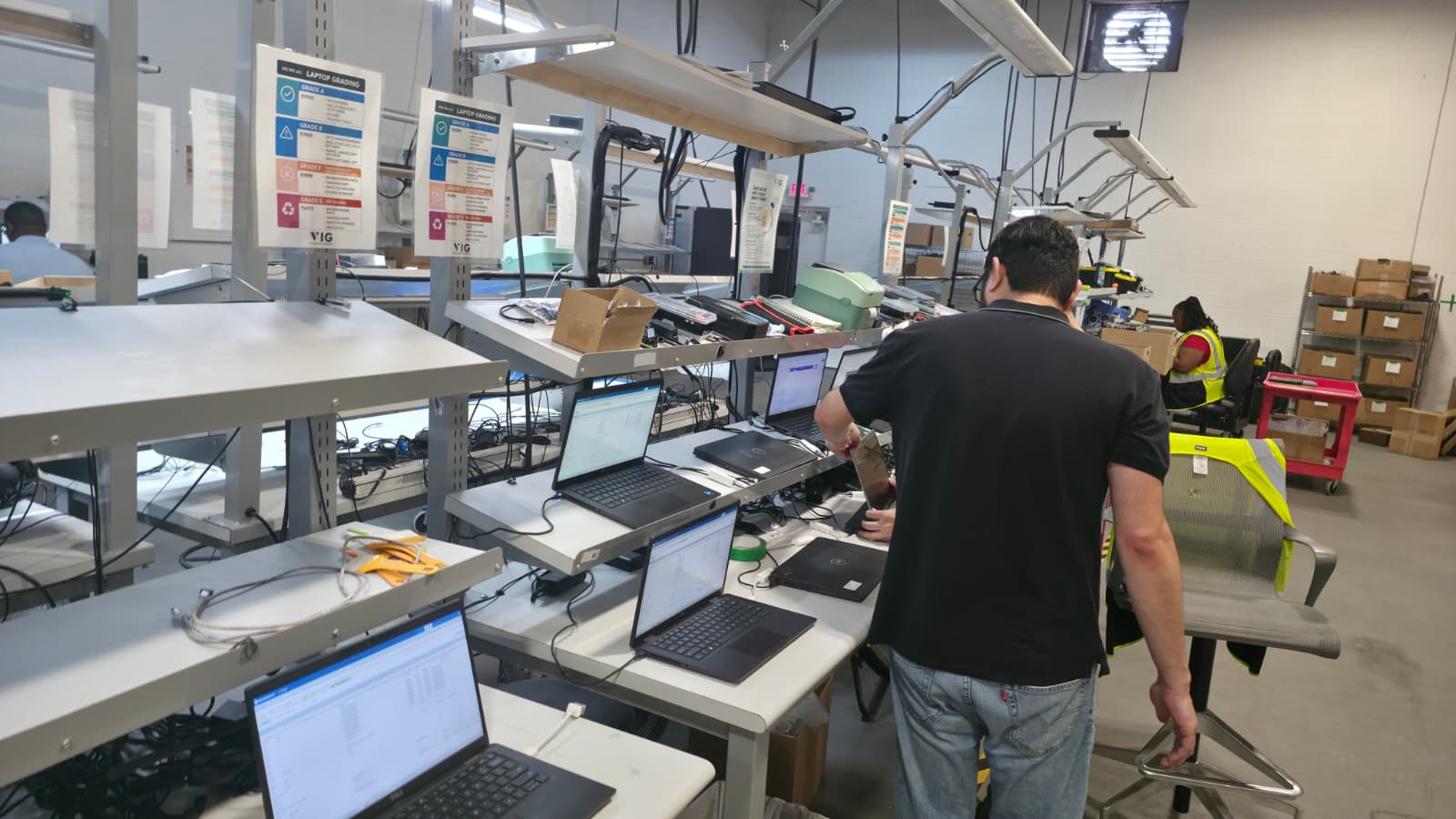 VIG technicians grading and auditing laptops along the inspection line